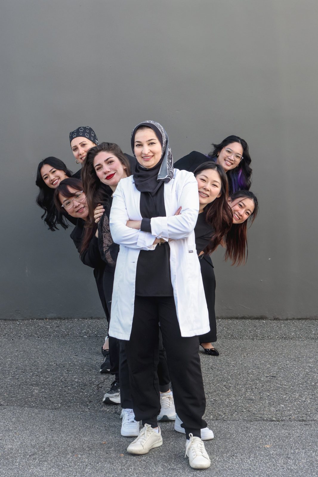 Dr. Rania Ataia in a white coat with the iSmile Dental team lined up behind her in Langley, BC